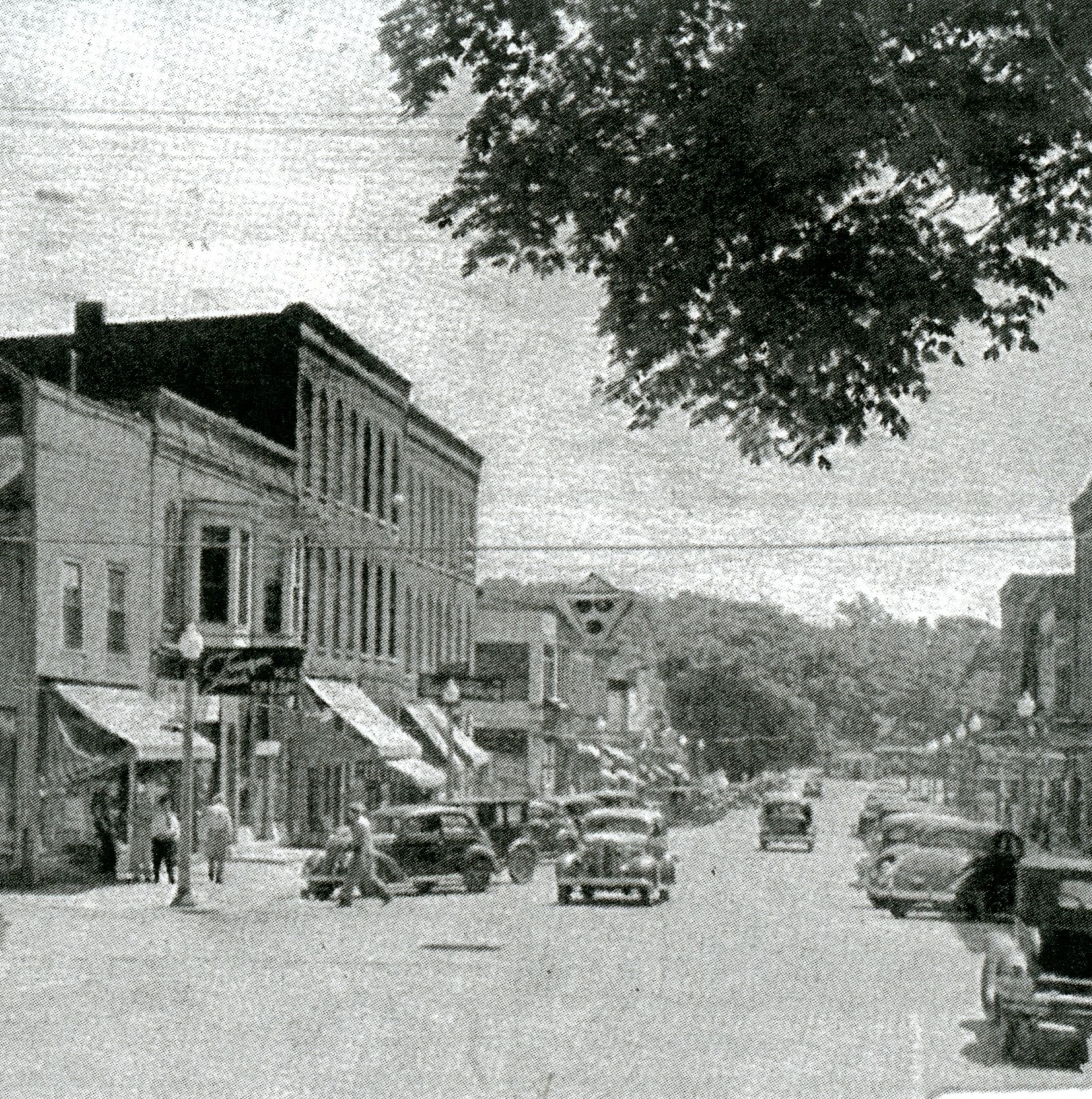 Historic photograph of Front Street storefronts and parked cars in Buchanan